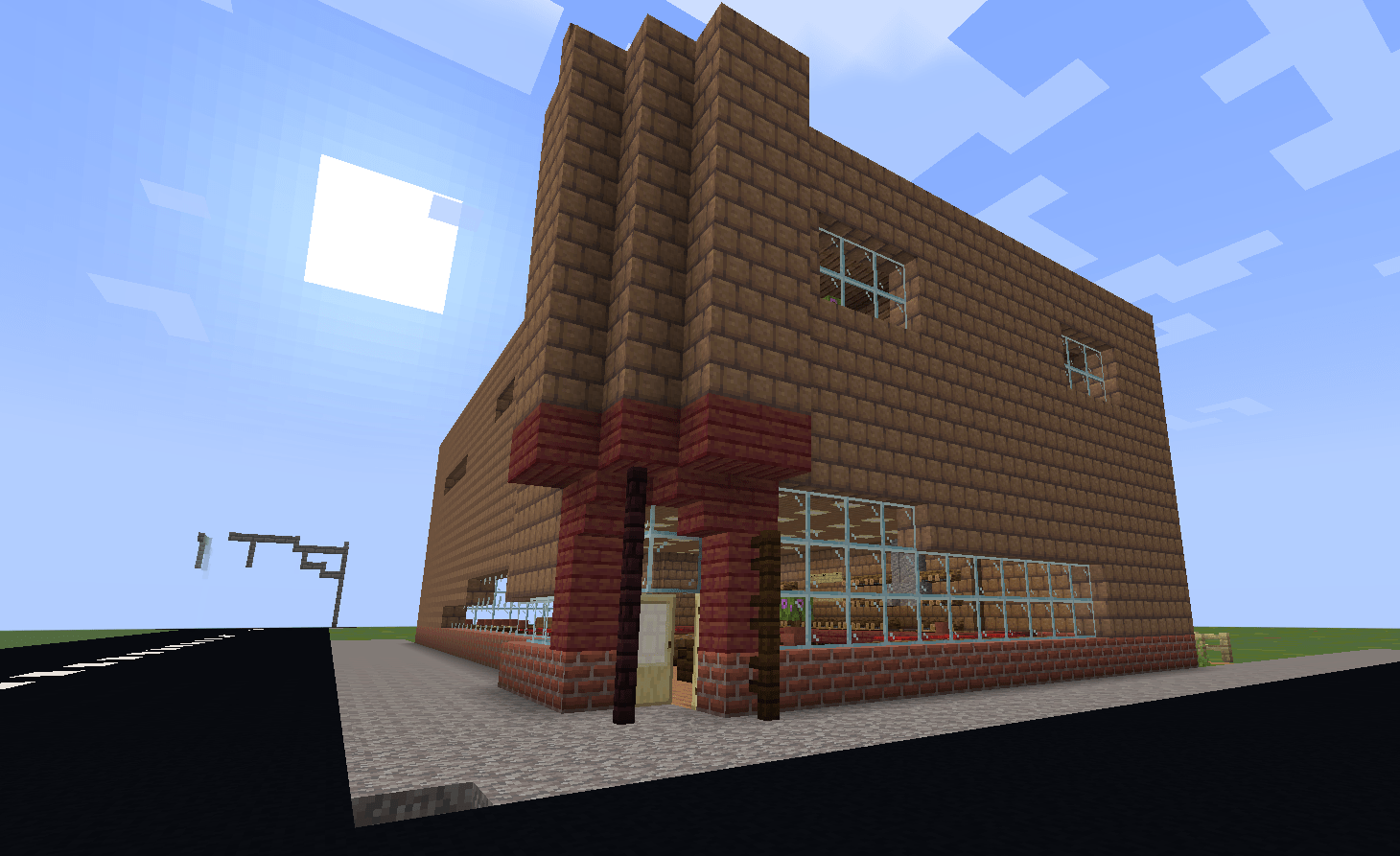 A photo of Field's Majestic Drugstore, taken from the east corner of the street. It is a two-story brick building, with a cutout in the corner for the door and plate glass windows.